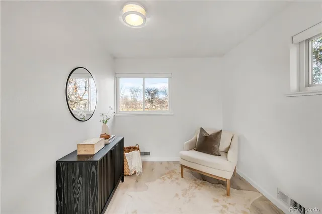 a living room with furniture a mirror and a table