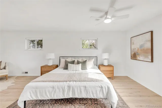 a bedroom with a bed and painting on the wall