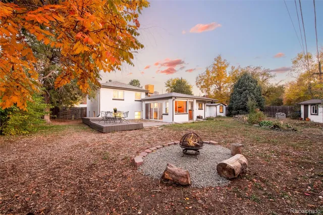 a backyard of a house with table and chairs