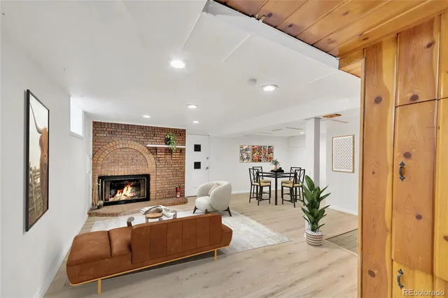 a view of an empty room with wooden floor fireplace and a window