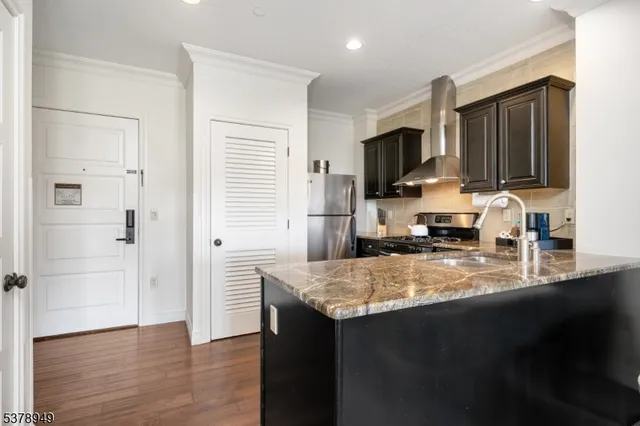 a kitchen with stainless steel appliances granite countertop a sink refrigerator and microwave