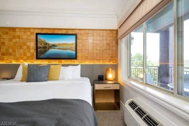 a bedroom with a bed and a large window