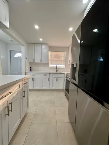 a large kitchen with stainless steel appliances lots of counter top space cabinets and a sink