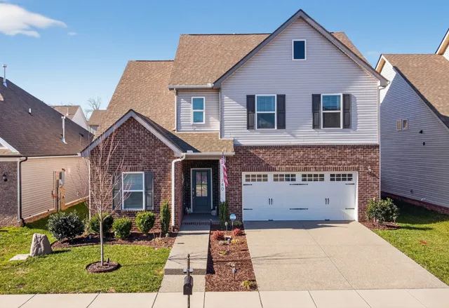 a front view of a house with a yard and garage