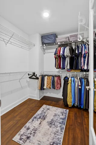 a view of walk in closet with clothes and shoes