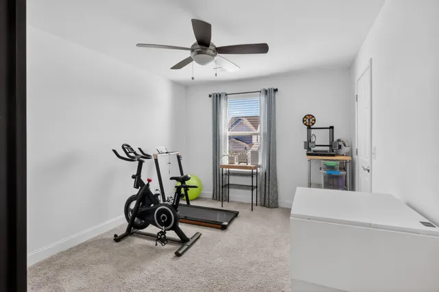 a view of a workspace with furniture and a ceiling fan