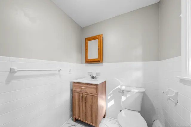 a bathroom with a toilet a sink and mirror
