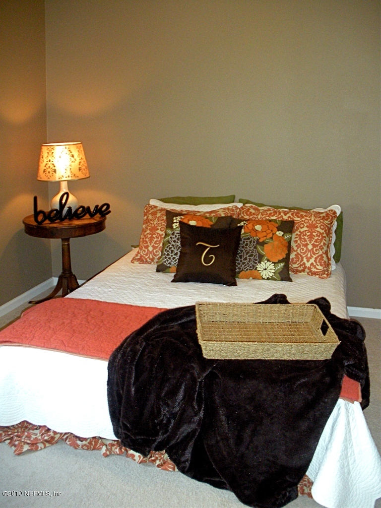 55 Amherst Place Ponte Vedra, FL 32081 - Photo 12 of 17 a bed sitting in a bedroom next to a lamp