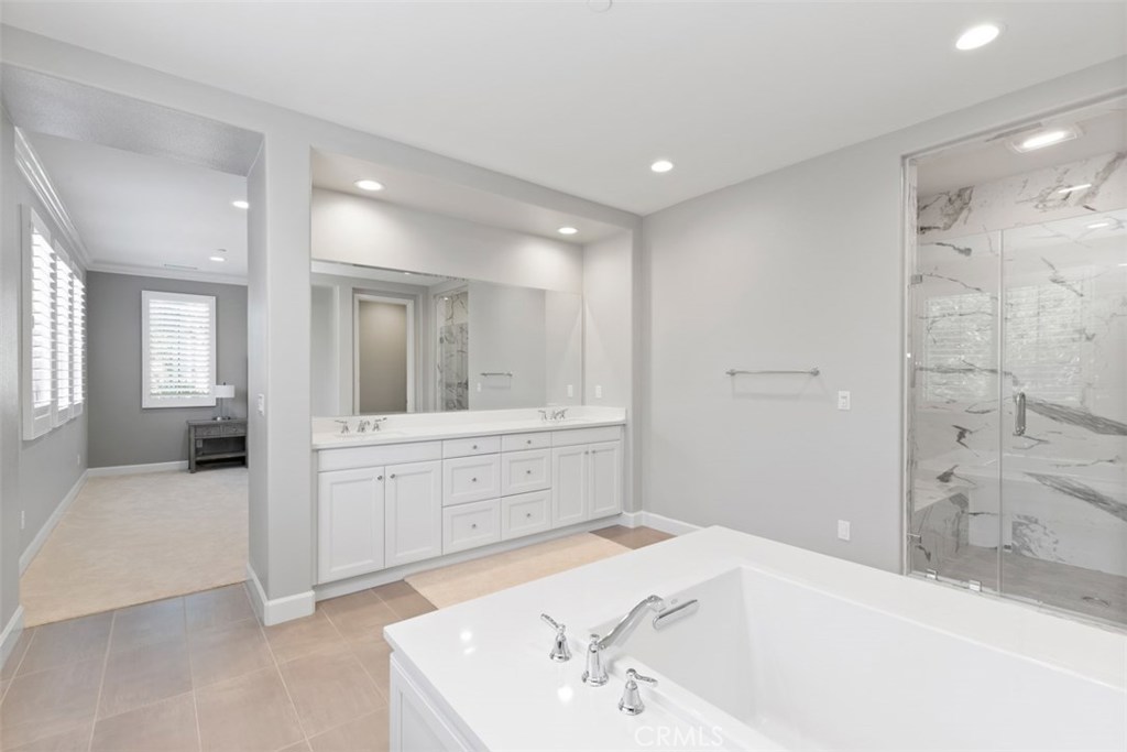 26 Lowland Irvine, CA 92602 - Photo 24 of 44 a bathroom with a tub sink and mirror