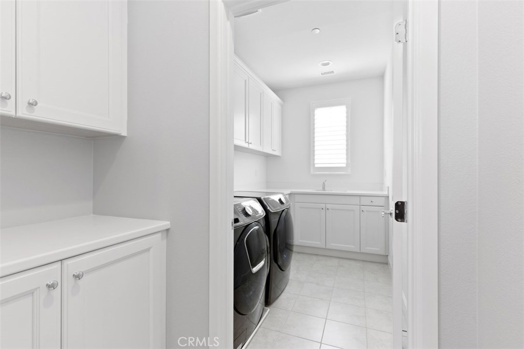 26 Lowland Irvine, CA 92602 - Photo 30 of 44 a utility room with cabinets washer and dryer