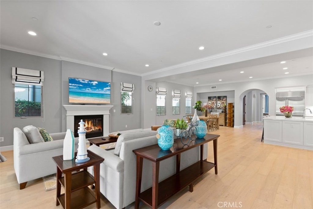 26 Lowland Irvine, CA 92602 - Photo 10 of 44 a living room with furniture a fireplace and a dining table with wooden floor