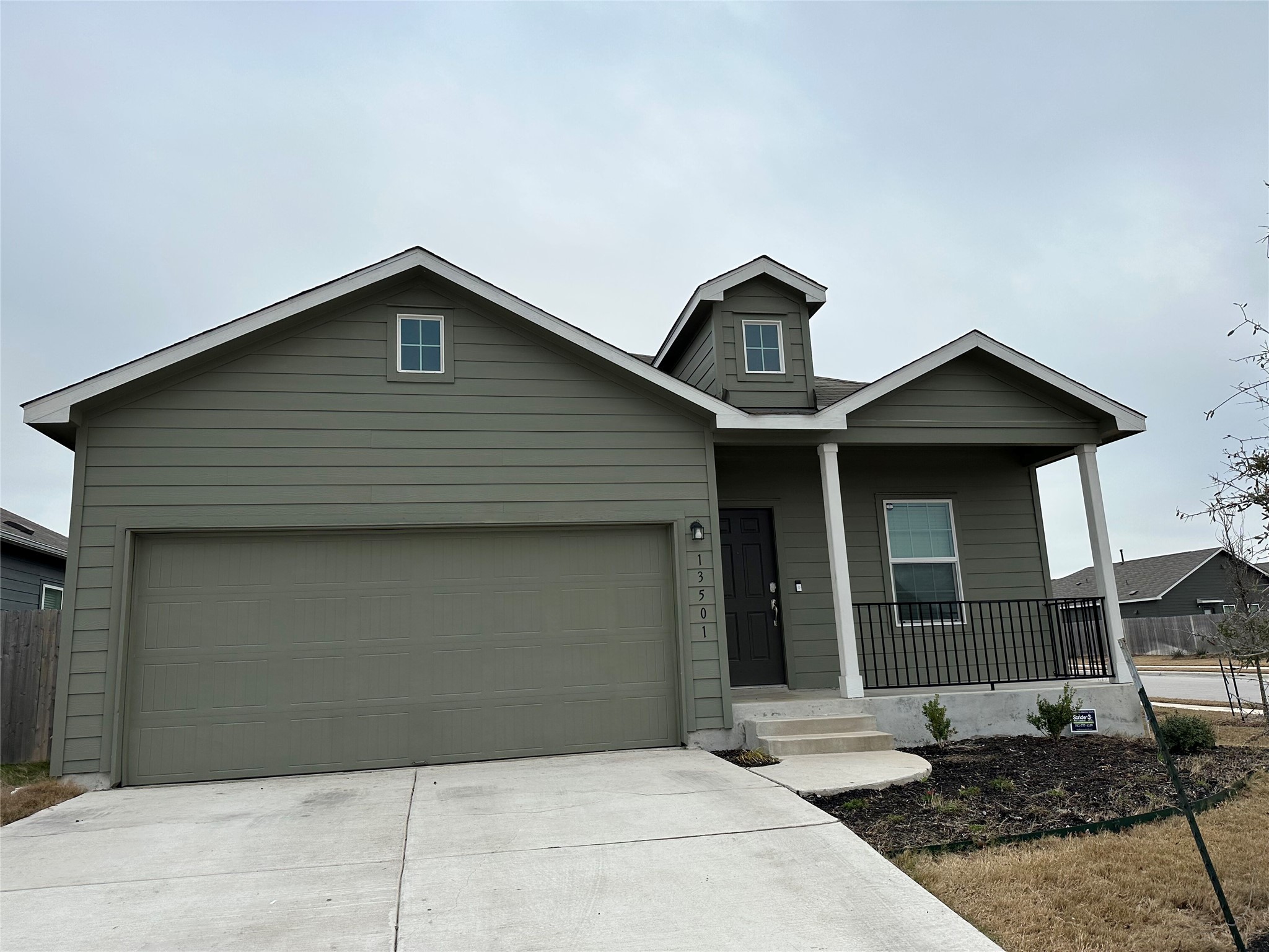 13501 Mussel Run Elgin, TX 78621 - Photo 1 of 28 Single-story residence featuring a covered front porch with white columns, a dormer window, and a two-car garage