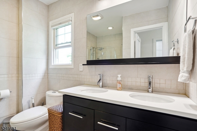 7 Undercliff Road Millburn, NJ 07041 - Photo 11 of 16 a bathroom with a double vanity sink toilet and a mirror