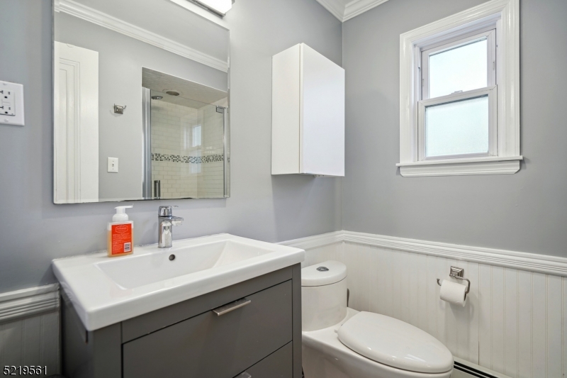 7 Undercliff Road Millburn, NJ 07041 - Photo 7 of 16 a bathroom with a sink toilet a mirror and next to a window