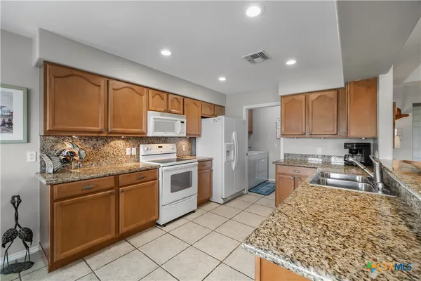 a kitchen with a sink stove and refrigerator