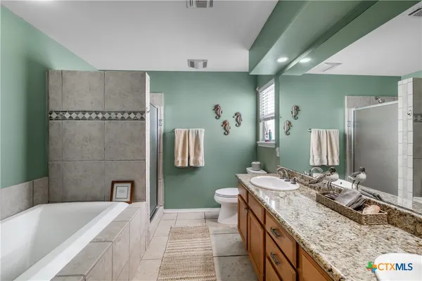 a bathroom with a granite countertop sink a mirror and a bathtub