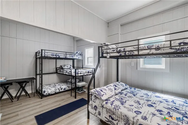 a bedroom with a bed and wooden floor