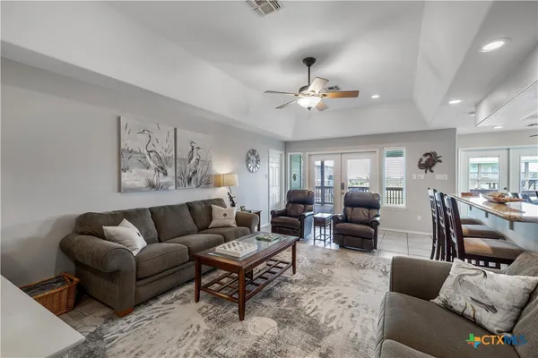 a living room with furniture a ceiling fan and a rug