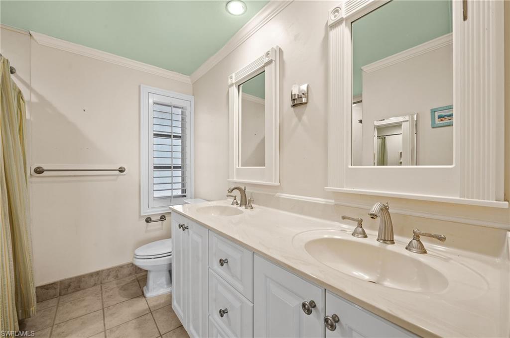 59 Pebble Beach Boulevard Naples, FL 34113 - Photo 22 of 32 a bathroom with a granite countertop sink toilet and shower