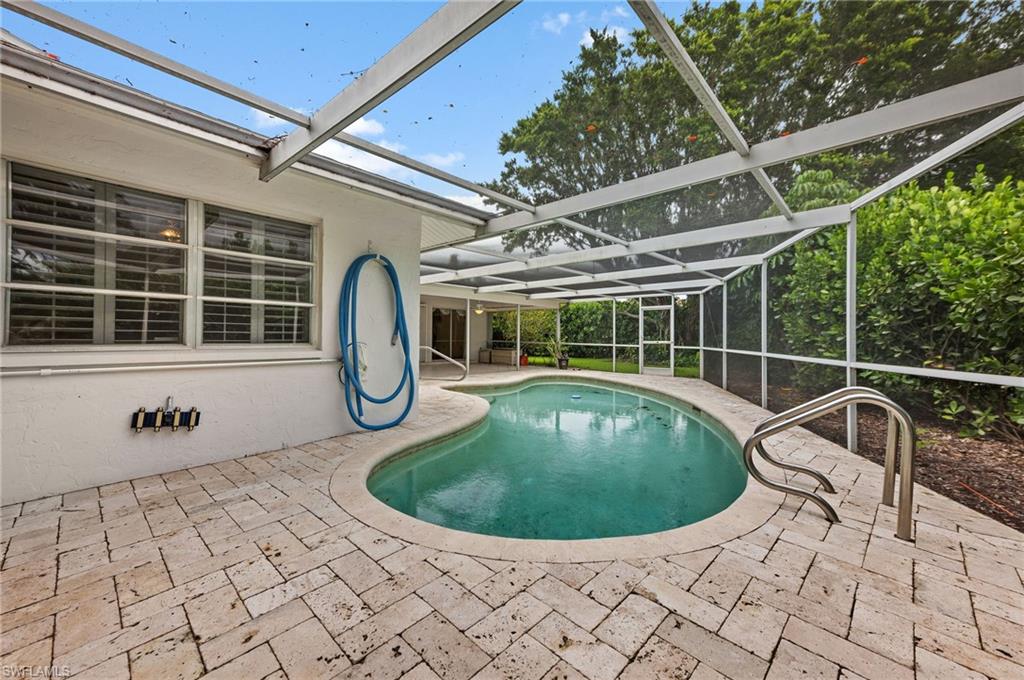 59 Pebble Beach Boulevard Naples, FL 34113 - Photo 29 of 32 a view of a swimming pool with a lounge chairs