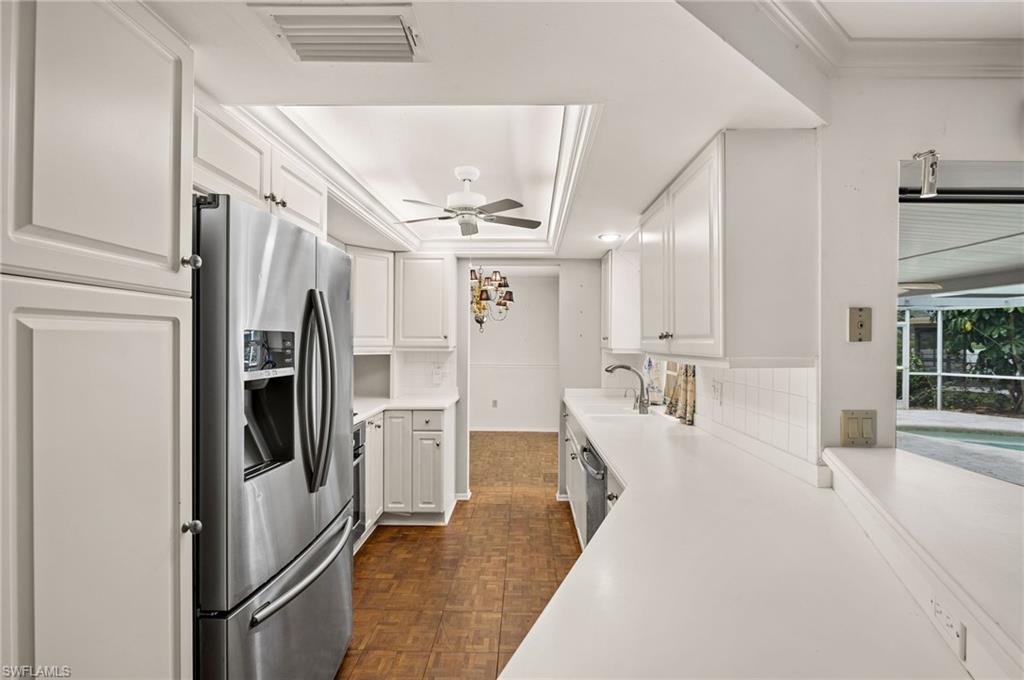 59 Pebble Beach Boulevard Naples, FL 34113 - Photo 10 of 32 a large white kitchen with stainless steel appliances