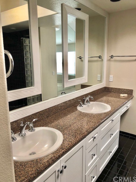 5 Torrigiani Aisle Irvine, CA 92606 - Photo 20 of 28 a bathroom with a granite countertop sink and a mirror