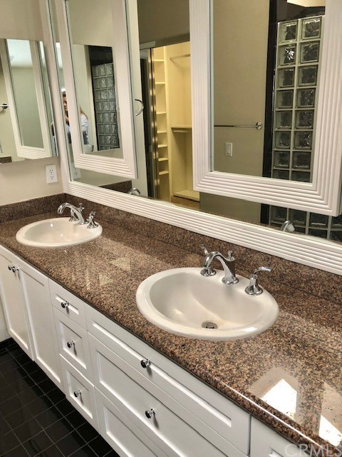 5 Torrigiani Aisle Irvine, CA 92606 - Photo 22 of 28 a bathroom with a granite countertop sink and a mirror