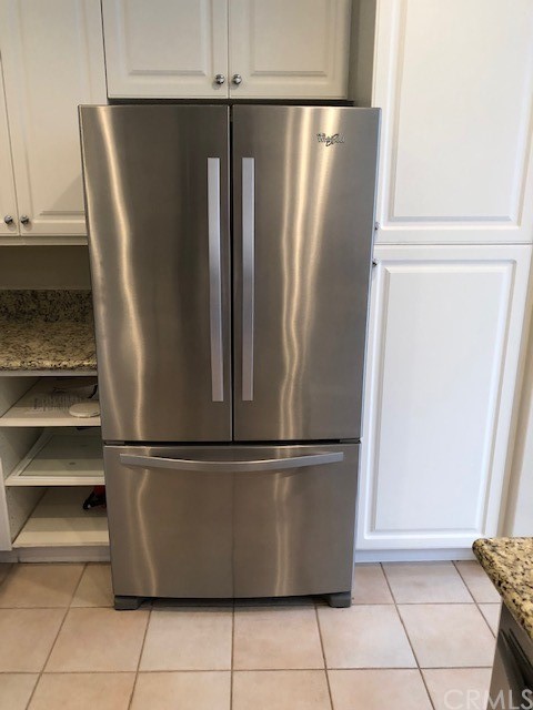 5 Torrigiani Aisle Irvine, CA 92606 - Photo 5 of 28 a view of a refrigerator in kitchen and an empty room with wooden floor
