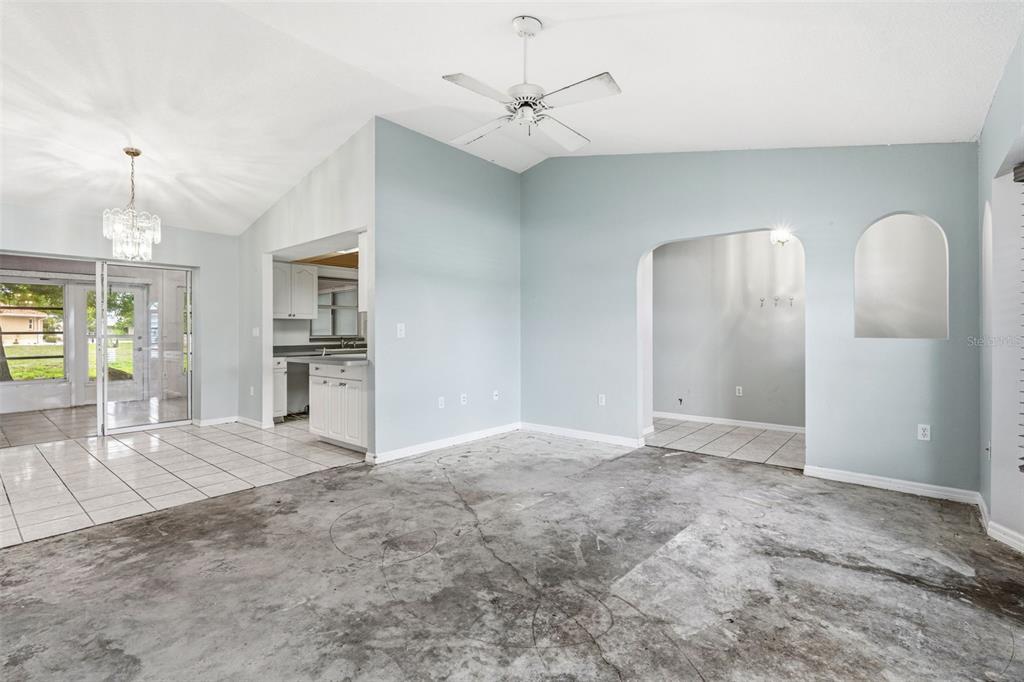 7510 Ligustrum Punta Gorda, FL 33955 - Photo 4 of 25 an empty room with chandelier fan and kitchen view