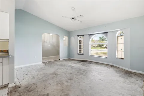 an empty room with windows and ceiling fan