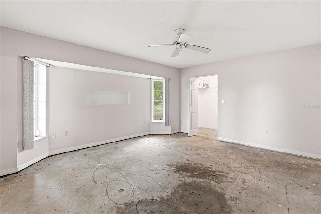 7510 Ligustrum Punta Gorda, FL 33955 - Photo 10 of 25 an empty room with chandelier fan and windows