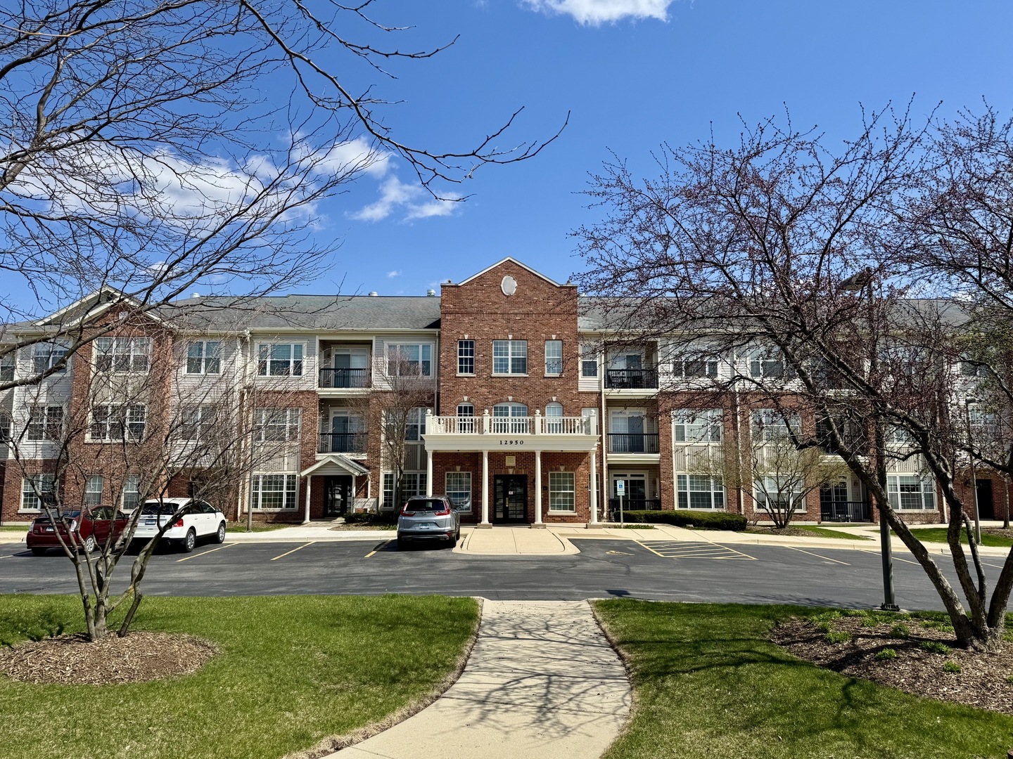 12950 Meadow View Court, Unit 109 Huntley, IL 60142 - Photo 1 of 1 a front view of a building with a garden