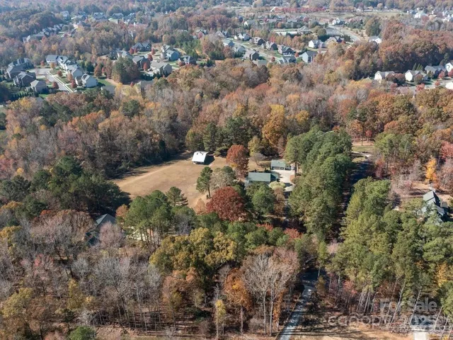 an aerial view of a houses with yard and trees