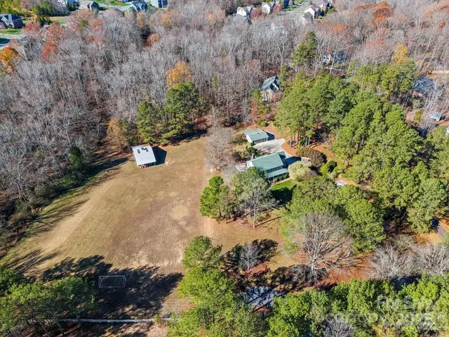 an aerial view of a house with a yard and trees