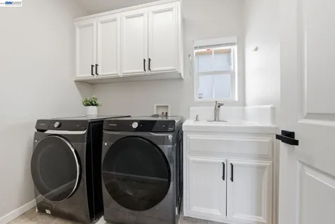 a utility room with sink dryer and washer