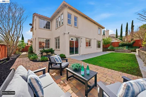 a view of an house with backyard and sitting area