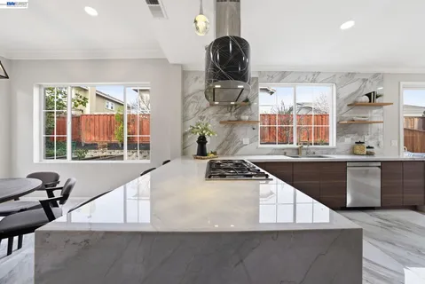 a kitchen with stainless steel appliances granite countertop a sink stove and wooden cabinets