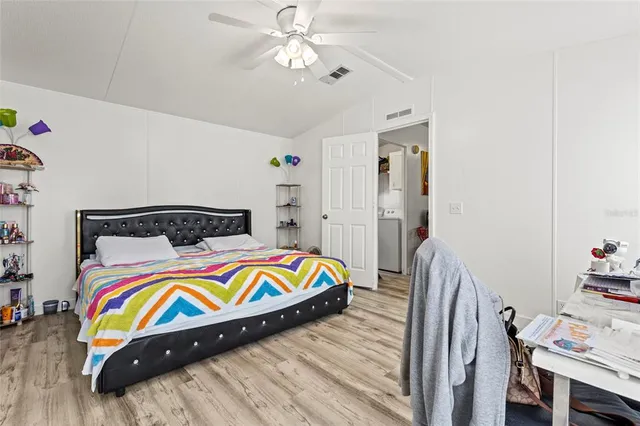 a bedroom with bed and wooden floor