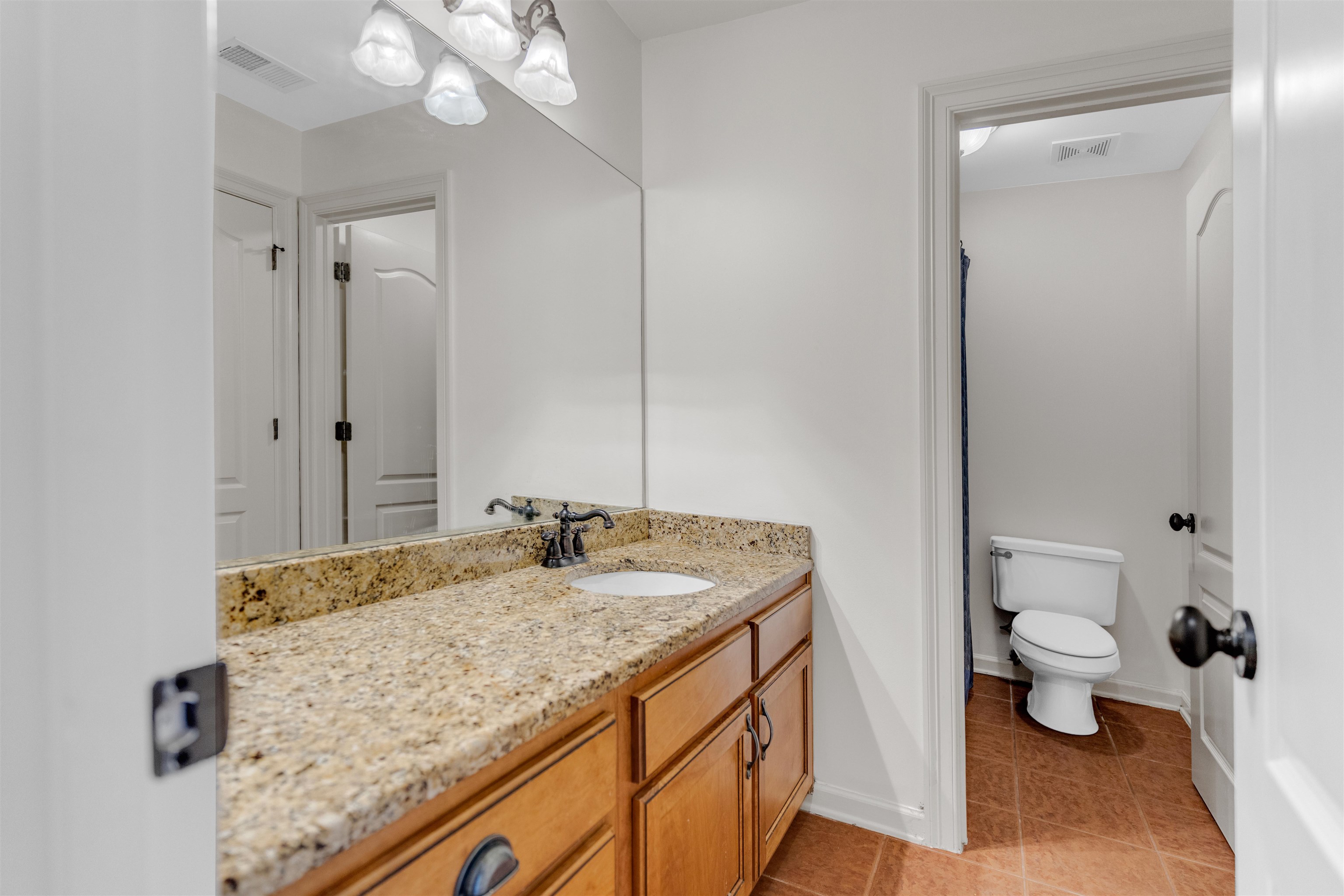 1075 Summer Spring Road Collierville, TN 38017 - Photo 30 of 40 a bathroom with a granite countertop sink a toilet and a mirror