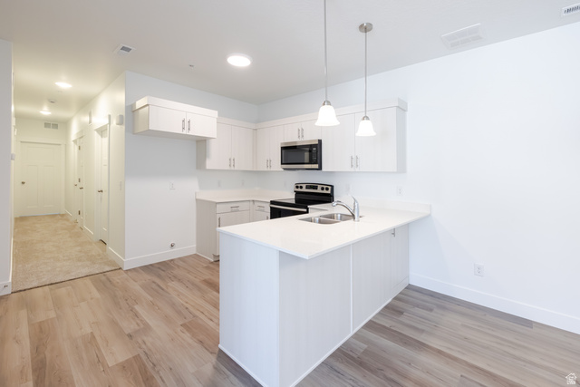 675 West 4500th South, Unit P204 Mapleton, UT 84664 - Photo 12 of 16 Contemporary kitchen with white cabinetry, stainless steel appliances, and a central island with a double basin sink