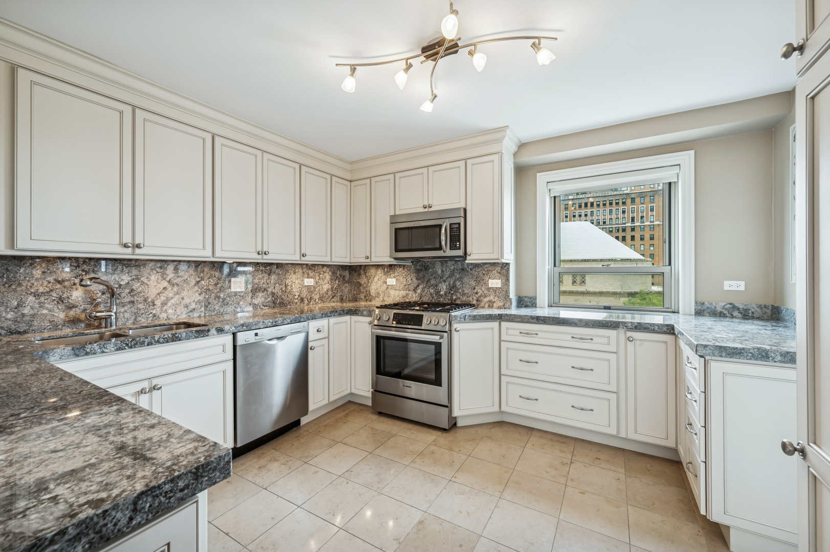 3470 North Lake Shore Drive, Unit 9BC Chicago, IL 60657 - Photo 13 of 21 a kitchen with granite countertop white cabinets stainless steel appliances and a sink