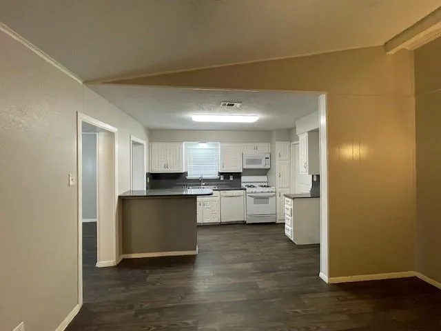 a kitchen with a refrigerator and a stove top oven
