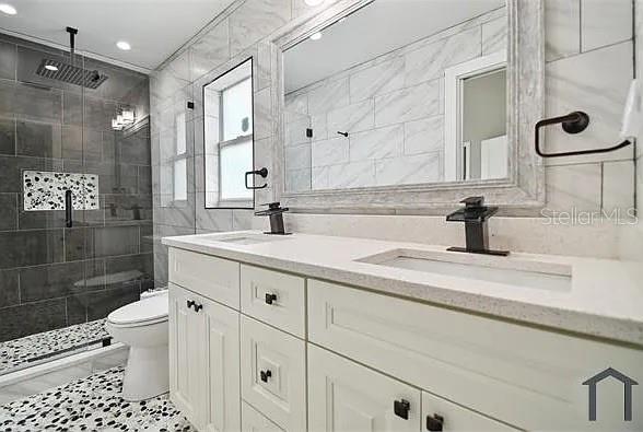 6745 Ralston Beach Circle Tampa, FL 33614 - Photo 21 of 39 a bathroom with a sink a toilet a shower and a mirror