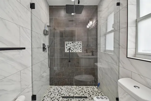 a bathroom with a shower a toilet and a sink