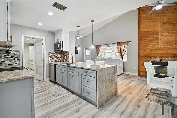 6745 Ralston Beach Circle Tampa, FL 33614 - Photo 5 of 39 a kitchen with stainless steel appliances kitchen island granite countertop a stove a sink and a refrigerator