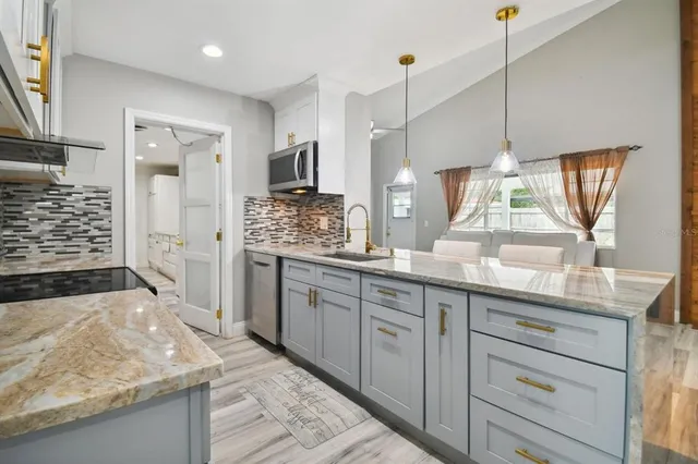 a kitchen with stainless steel appliances granite countertop a sink stove and refrigerator