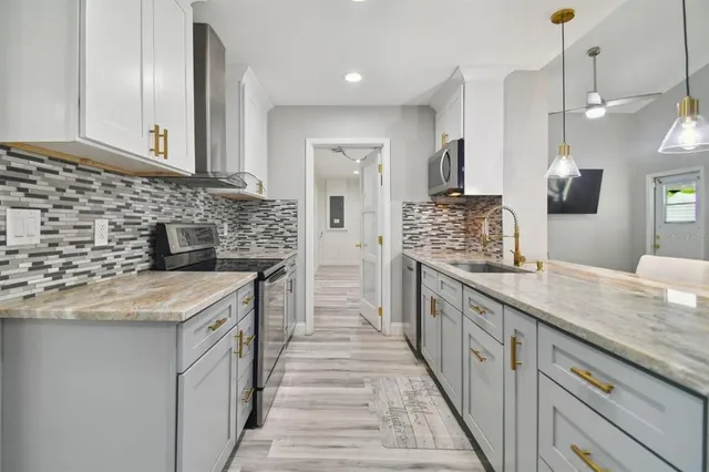 a kitchen with stainless steel appliances granite countertop a sink stove and cabinets