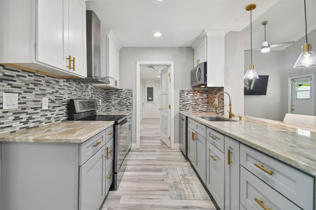 6745 Ralston Beach Circle Tampa, FL 33614 - Photo 9 of 39 a kitchen with stainless steel appliances granite countertop a sink stove and cabinets