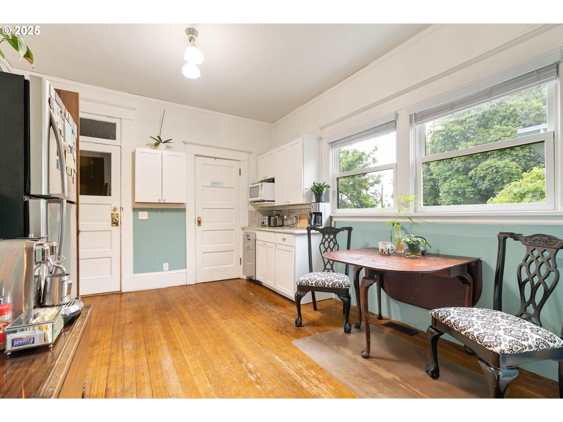 3906 South Kelly Avenue Portland, OR 97239 - Photo 17 of 42 a kitchen with a table chairs refrigerator and microwave