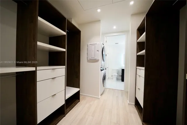 a view of walk in closet with clothes and shoes